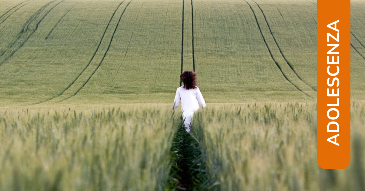 Una ragazza avanza in un campo di grano immacolato lasciando dietro di sé il segno del proprio passaggio