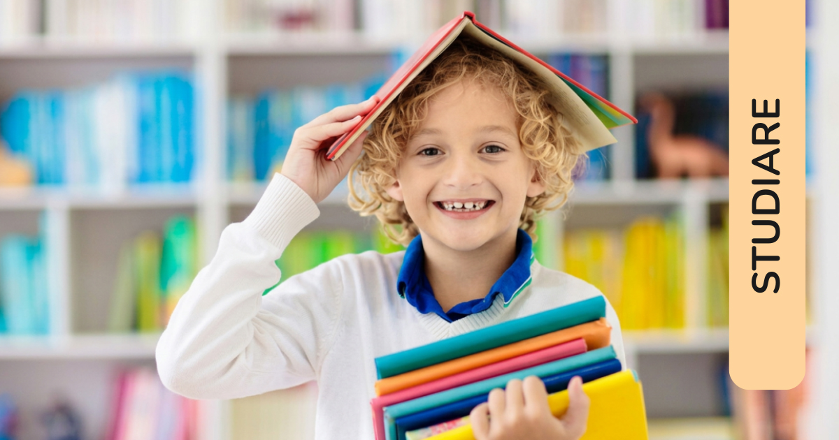 Un bambino sorridente davanti ad una libreria con un libro aperto appoggiato sulla testa a mo' di cappello