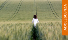 Una ragazza avanza in un campo di grano immacolato lasciando dietro di sé il segno del proprio passaggio